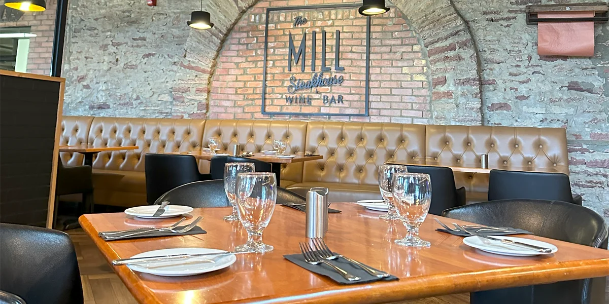 The Mill Steakhouse table and benches against brick wall